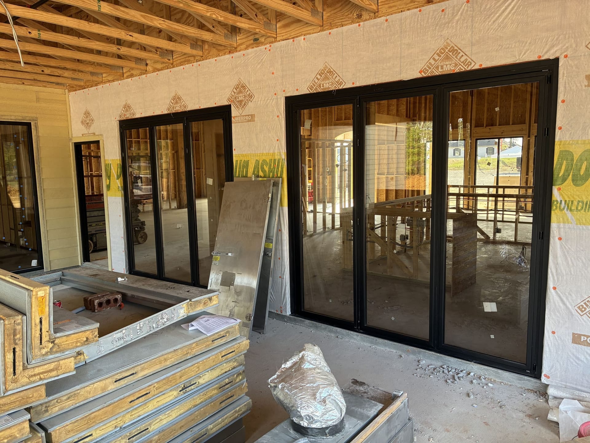 Two black-framed bifold glass door systems installed during new commercial construction