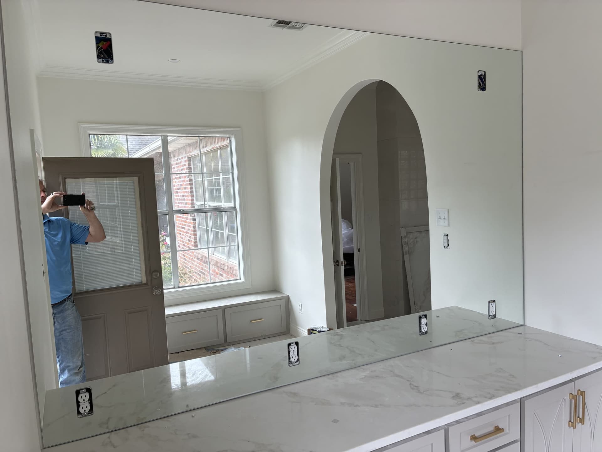 Large frameless mirror installed above a marble vanity